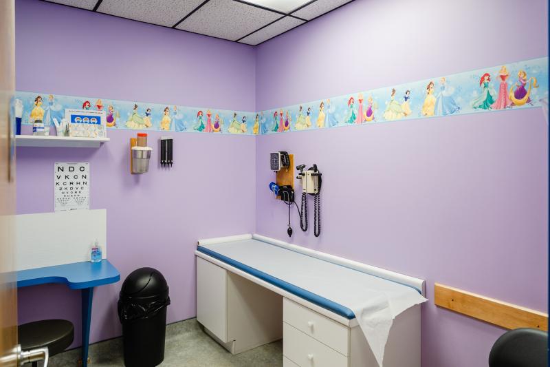a pediatric exam room with purple walls